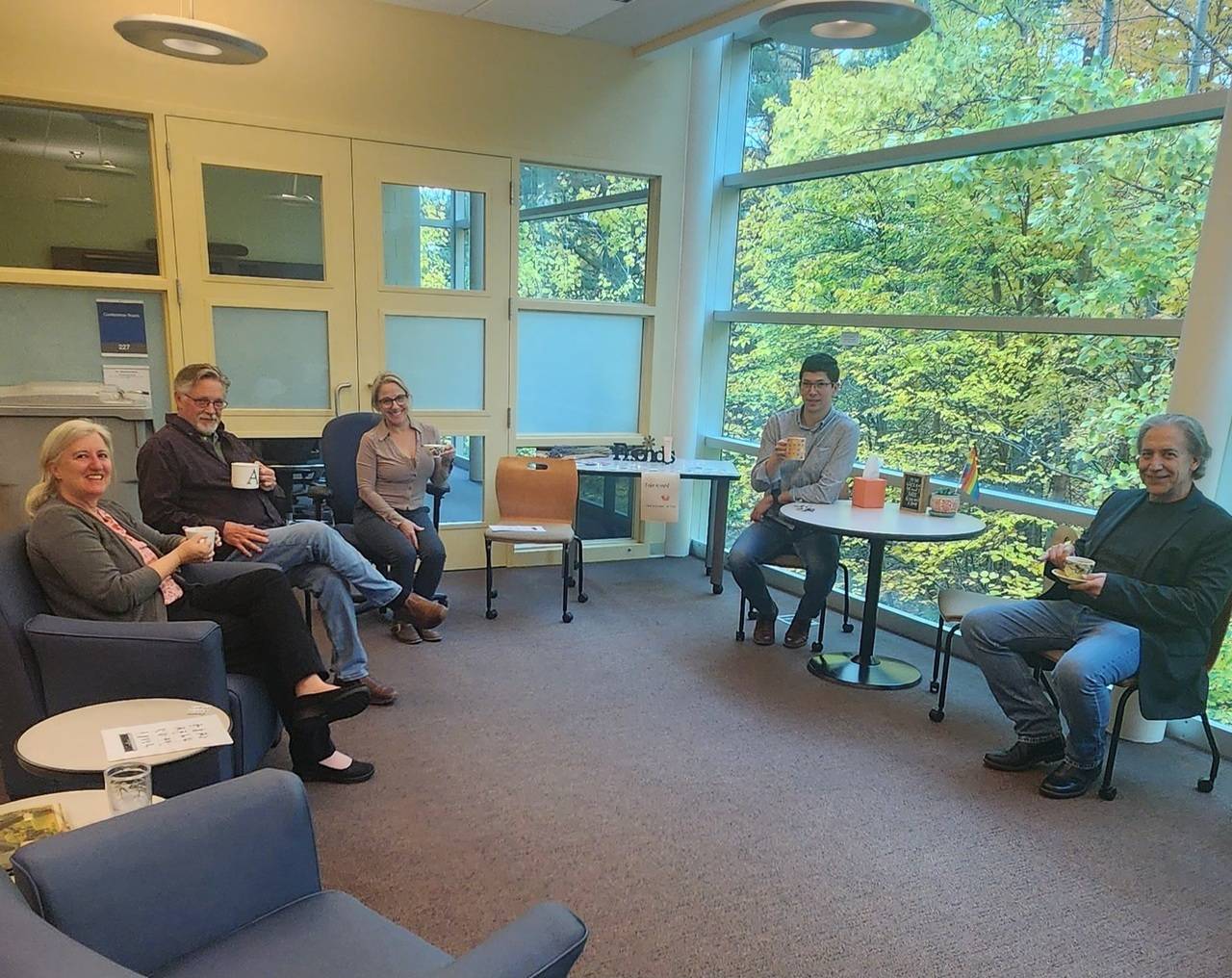 a group of people sitting in a room drinking tea